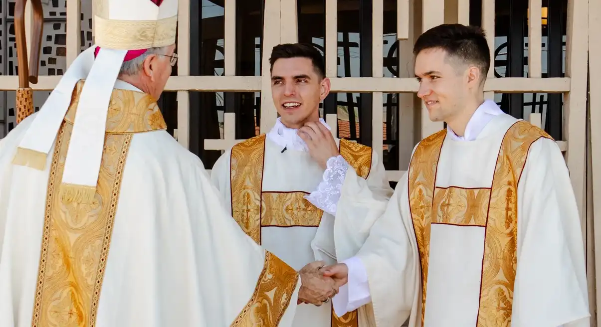 Bishop John Dolan handshaking seminarians