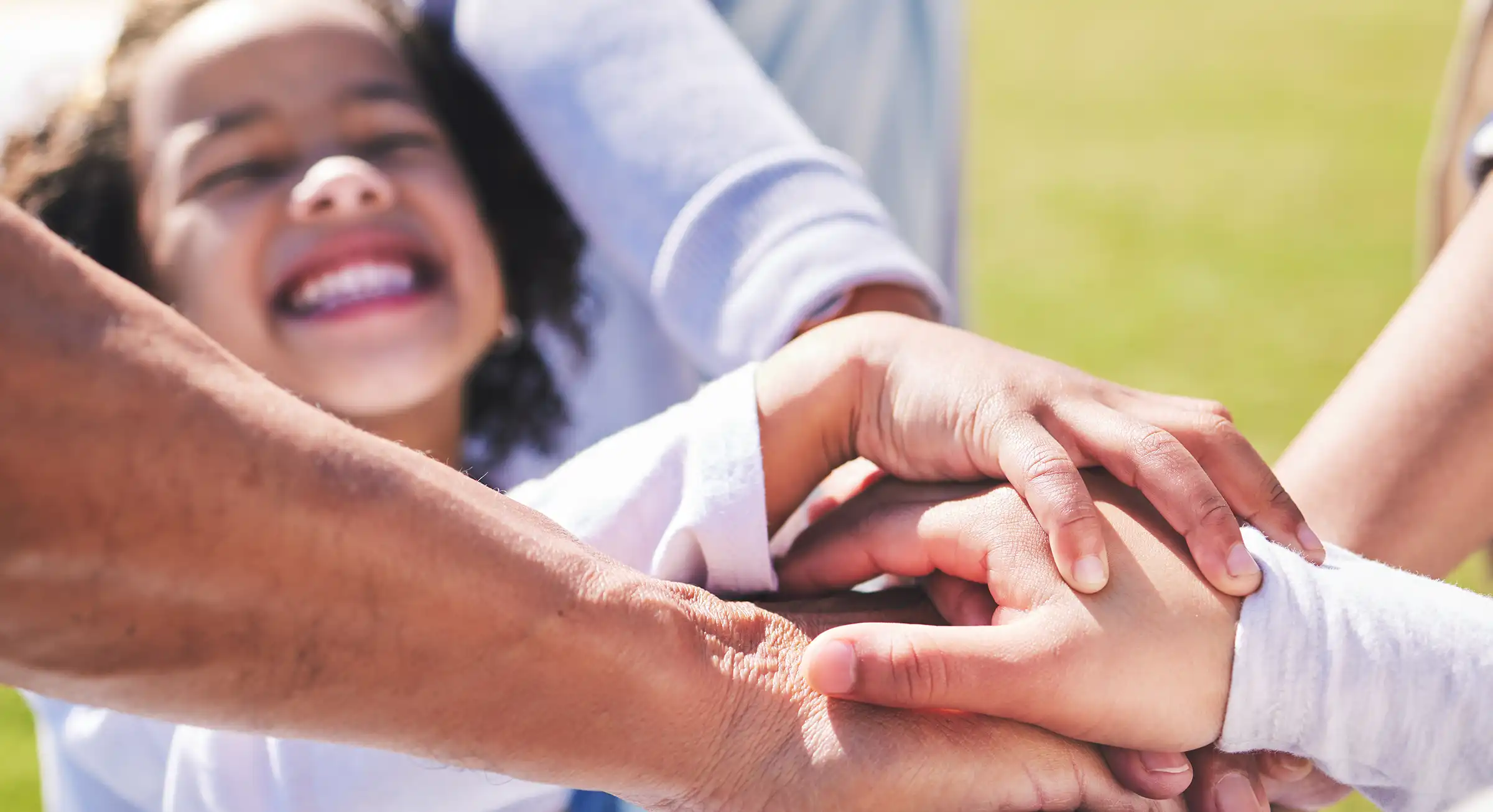 Hands, stack and happy family with child for playing on field with support, bonding and love